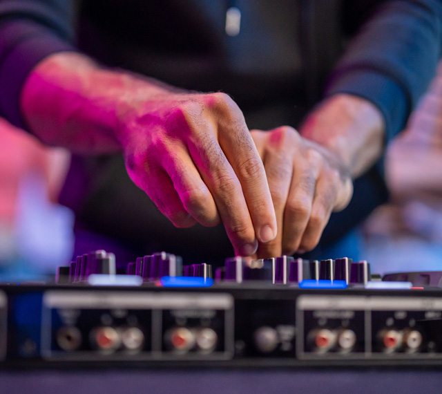 Hände eines DJs am Mischpult