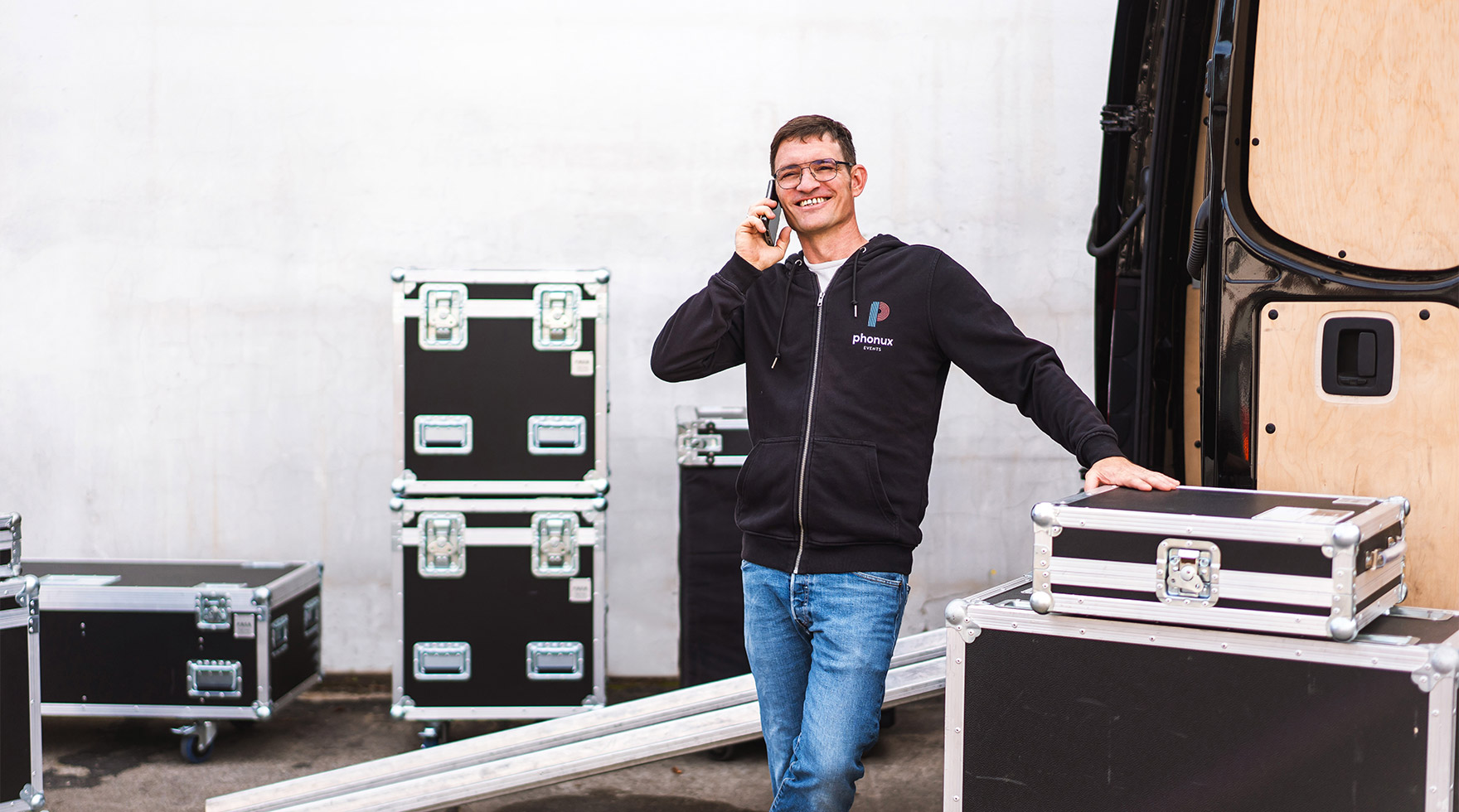 Techniker steht neben Transporter und telefoniert